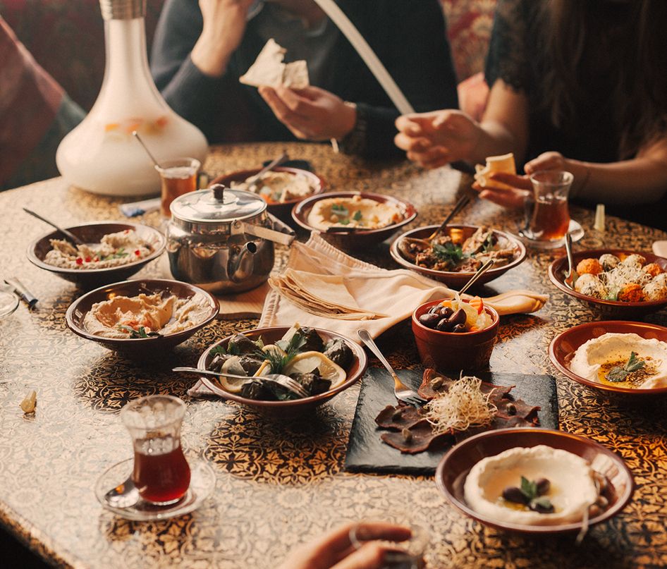 Ein Tisch mit verschiedenen orientalischen Gerichten, darunter Reis, Gemüse und Fleischspezialitäten